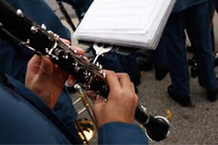 Band member playing a wind instrument with sheet music